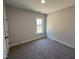 Neutral bedroom featuring plush carpet, natural light from the window, and a clean, simple design at 47 Royal Ave, Selma, NC 27576