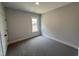 This carpeted bedroom features a single window letting in natural light and neutral-colored walls at 47 Royal Ave, Selma, NC 27576