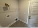 Practical laundry room space with neutral walls, tile flooring, washer/dryer hookups, and upper shelving at 47 Royal Ave, Selma, NC 27576