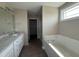Bathroom with granite counters, dual sinks, soaking tub, walk-in shower, and tile flooring at 48 Silver Ct, Smithfield, NC 27577