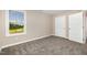 This bedroom features neutral walls, carpet flooring, and a window view with two doors at 48 Silver Ct, Smithfield, NC 27577