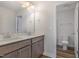 Bright bathroom featuring a double sink vanity, a walk-in shower, and toilet at 54 Barony Ln, Smithfield, NC 27577