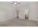Spacious bedroom with neutral carpet, a ceiling fan, and doorway access to the ensuite bathroom at 54 Barony Ln, Smithfield, NC 27577