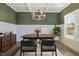 Virtually staged dining room with decorative wainscoting, modern chandelier, table, and furniture set at 54 Barony Ln, Smithfield, NC 27577