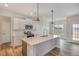 Modern kitchen features white cabinets, stainless steel appliances, and a large island with quartz countertops at 54 Barony Ln, Smithfield, NC 27577