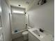 Bathroom with white tub and shower, toilet, vanity, and a black faucet and fixtures at 56 Bailey-Boykin Rd, Selma, NC 27576