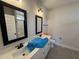 Bathroom featuring double sinks, a white vanity, two framed mirrors, and a shower with glass door at 56 Bailey-Boykin Rd, Selma, NC 27576