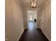 A home hallway with dark hardwood floors and a view into the living room with white trim and fireplace at 56 Bailey-Boykin Rd, Selma, NC 27576