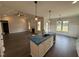 A kitchen with white cabinets, stainless appliances, an island sink, and a view into the living room at 56 Bailey-Boykin Rd, Selma, NC 27576