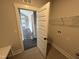 A laundry room with tile floors, a wire shelf, and white door leading to the kitchen at 56 Bailey-Boykin Rd, Selma, NC 27576