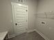Clean, simple laundry room with white door and shelving at 56 Bailey-Boykin Rd, Selma, NC 27576