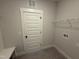 Laundry room featuring tile floors, a white door, and a white wire storage shelf at 56 Bailey-Boykin Rd, Selma, NC 27576
