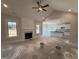 Open concept living room with a fireplace, shiplap accents, and vaulted ceilings with fan at 56 Bailey-Boykin Rd, Selma, NC 27576
