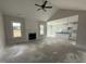 Bright living room featuring vaulted ceiling, shiplap fireplace, and seamless transition to kitchen with modern fixtures at 56 Bailey-Boykin Rd, Selma, NC 27576