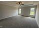Spacious main bedroom with a tray ceiling, ceiling fan, carpet and natural light from two windows at 56 Bailey-Boykin Rd, Selma, NC 27576