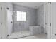 Modern bathroom featuring a glass enclosed shower, soaking tub, and stylish gray tiling at 5928 Terrington Ln, Raleigh, NC 27606