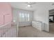 Bright Bedroom with pink accent wall, crib, changing table and neutral carpet at 5928 Terrington Ln, Raleigh, NC 27606