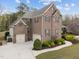 Aerial view of a brick two-story house with attached two-car garage and well-manicured lawn at 5928 Terrington Ln, Raleigh, NC 27606