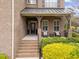 Inviting brick home entrance featuring a covered porch and decorative landscaping at 5928 Terrington Ln, Raleigh, NC 27606