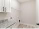 Bright laundry room with granite countertops and overhead shelving at 609 Tuscany Cir, Princeton, NC 27569