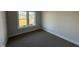 Bedroom with neutral walls, plush carpeting, and a view of the outdoors through a double window at 612 Tuscany Cir, Princeton, NC 27569
