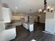 Modern kitchen featuring white cabinets, granite countertops, stainless steel appliances, and an island with a sink at 612 Tuscany Cir, Princeton, NC 27569