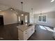 Open kitchen with granite island overlooking the living area, featuring dark wood floors and modern finishes at 612 Tuscany Cir, Princeton, NC 27569