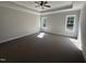 Sun-filled main bedroom with tray ceiling, neutral walls, plush carpet, and a ceiling fan at 612 Tuscany Cir, Princeton, NC 27569