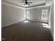 Large primary bedroom featuring tray ceiling, neutral carpet, and bright windows at 612 Tuscany Cir, Princeton, NC 27569