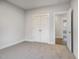Bedroom with closet and adjoining room, features neutral carpet and wall colors at 613 Tuscany Cir, Princeton, NC 27569