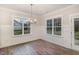 Bright dining area showcasing wood-look floors, wainscoting, and an elegant chandelier at 613 Tuscany Cir, Princeton, NC 27569