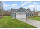 Side view of a home showcasing a pristine two-car garage, manicured lawn, and inviting curb appeal at 613 Tuscany Cir, Princeton, NC 27569