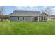 A well maintained lawn in the backyard features the rear exterior of the home with complementary trim at 613 Tuscany Cir, Princeton, NC 27569
