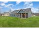 The rear exterior features blue siding, a screened in porch, and a well-maintained lawn at 613 Tuscany Cir, Princeton, NC 27569