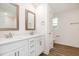 Bright bathroom featuring a double sink vanity, quartz countertops, framed mirrors, and wood-look flooring at 65 Barony Ln, Smithfield, NC 27577