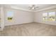 Spacious bedroom with a tray ceiling, neutral carpet, and dual windows offering plenty of natural light at 65 Barony Ln, Smithfield, NC 27577