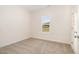 Bedroom featuring neutral carpet, a single window, and a white paneled door at 65 Barony Ln, Smithfield, NC 27577
