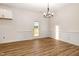 An empty dining room with natural light, chair rail, modern lighting, and wood-look floors at 65 Barony Ln, Smithfield, NC 27577