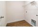 A compact laundry room with wood-look flooring and a convenient wire shelf above the washer-dryer hookups at 65 Barony Ln, Smithfield, NC 27577