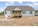 Exterior back view of a house with a wooden porch and a yard at 68 Tee Dr, Selma, NC 27576