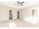Large carpeted primary bedroom has a tray ceiling, ceiling fan, and doorway to the primary bathroom at 68 Tee Dr, Selma, NC 27576