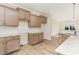 The kitchen has wood cabinets, tile backsplash, granite countertops, stainless steel sink, and a wood floor at 68 Tee Dr, Selma, NC 27576