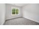 A bright, neutrally decorated bedroom features a large window offering natural light and pleasant views at 702 Tuscany Cir, Princeton, NC 27569
