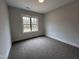 This carpeted bedroom provides a serene and calming atmosphere with its light gray walls and natural light at 702 Tuscany Cir, Princeton, NC 27569