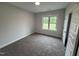 Cozy bedroom with plush carpeting, a bright window, and neutral paint; perfect for relaxation at 702 Tuscany Cir, Princeton, NC 27569
