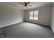 Bedroom with large window, neutral walls, plush carpet and a ceiling fan at 702 Tuscany Cir, Princeton, NC 27569