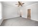 A carpeted bedroom with a ceiling fan and two open doorways at 702 Tuscany Cir, Princeton, NC 27569