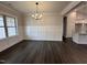 Bright dining room with wainscoting, hardwood floors, and modern chandelier at 702 Tuscany Cir, Princeton, NC 27569