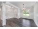 Elegant dining area with stylish light fixtures, wainscoting, and dark wood-look flooring at 702 Tuscany Cir, Princeton, NC 27569
