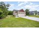 View of a large two-car garage with an extended driveway and a well-kept lawn at 702 Tuscany Cir, Princeton, NC 27569